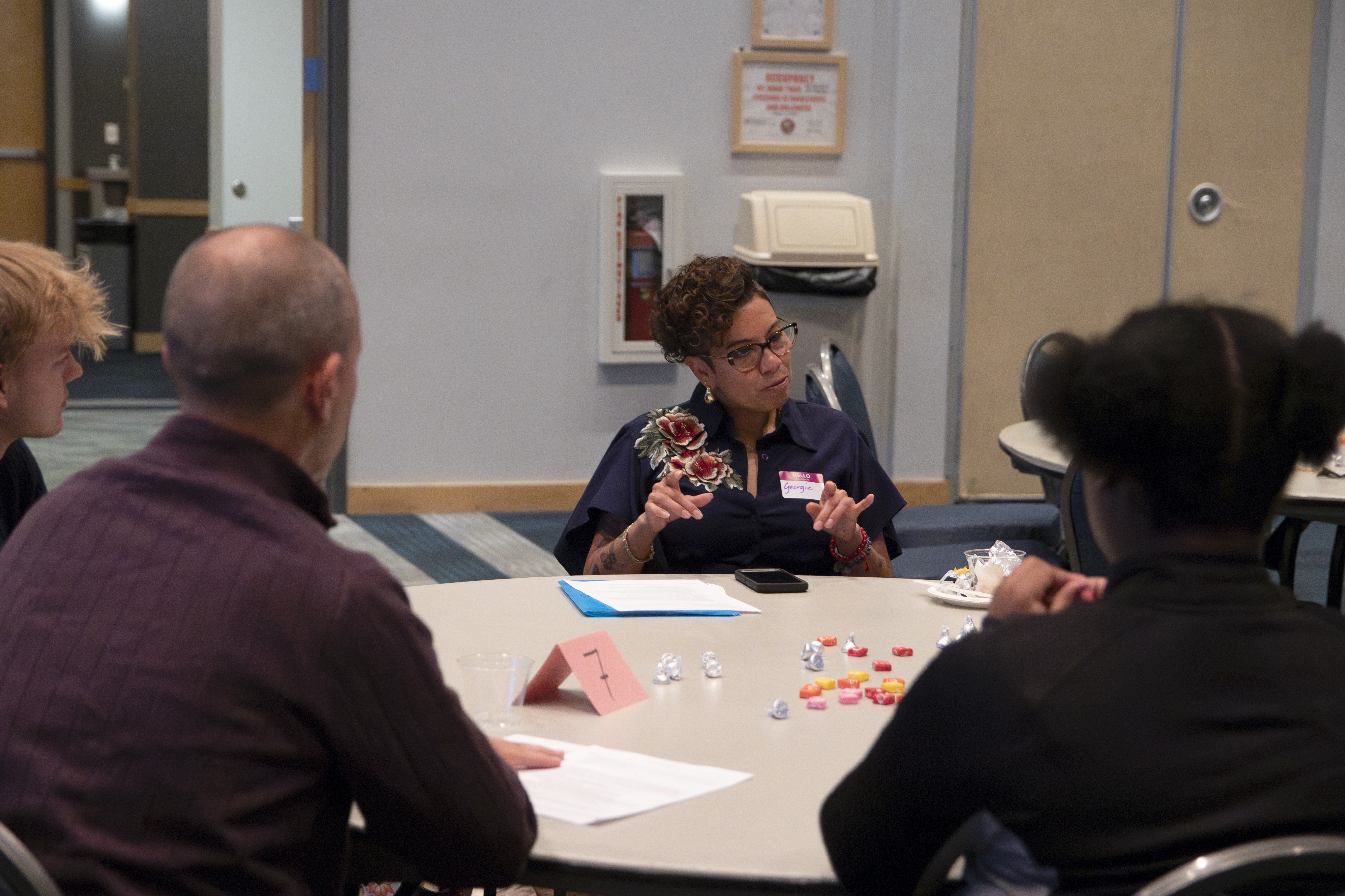 Event participants sit and talk to each other at a round table.